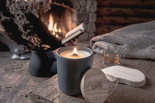 Twig wood wick candle burning beside fireplace, hand-poured on the Sunshine Coast BC