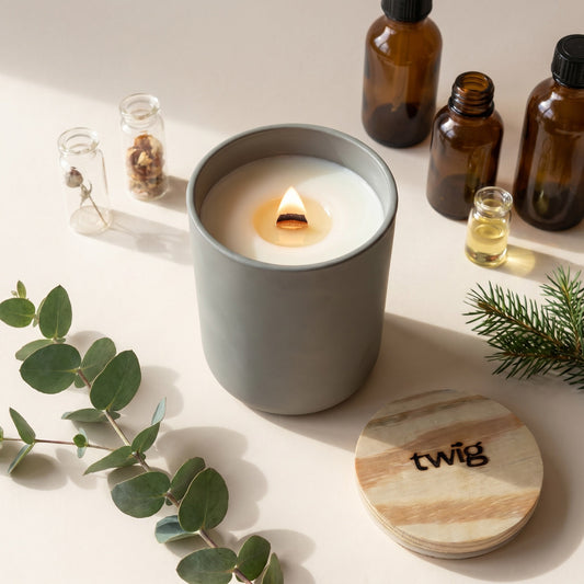 Twig wood wick candle burning beside fragrance oil vials, eucalyptus and fir — small-batch clean fragrance made in Canada