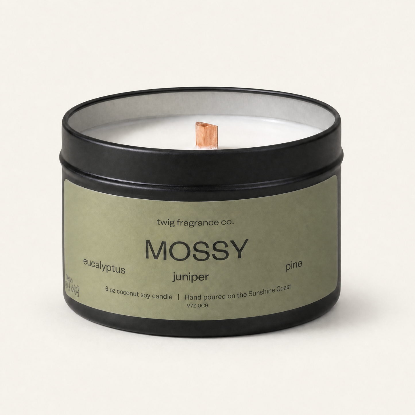 Candle in a black tin labeled 'Mossy' on a white background