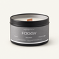 Candle in a black tin labeled 'Foggy' with a gray label on a white background