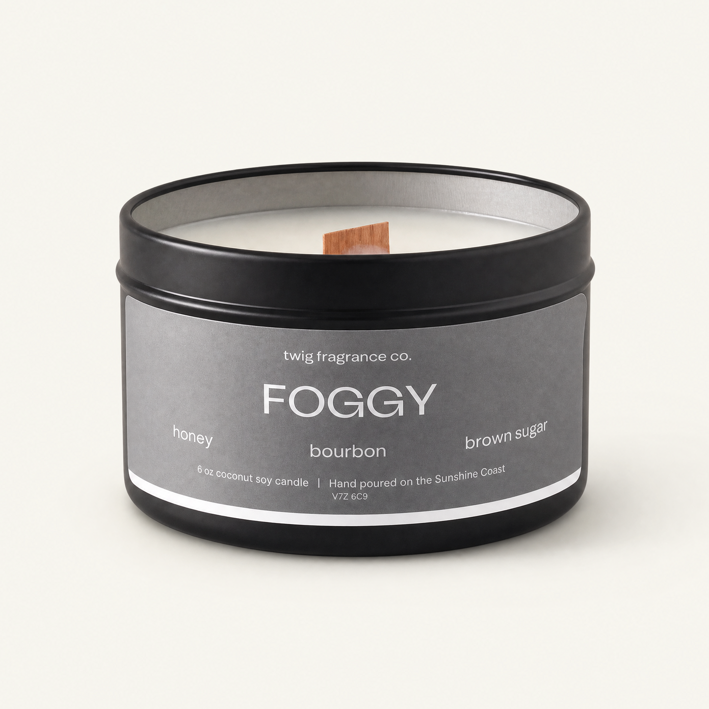 Candle in a black tin labeled 'Foggy' with a gray label on a white background